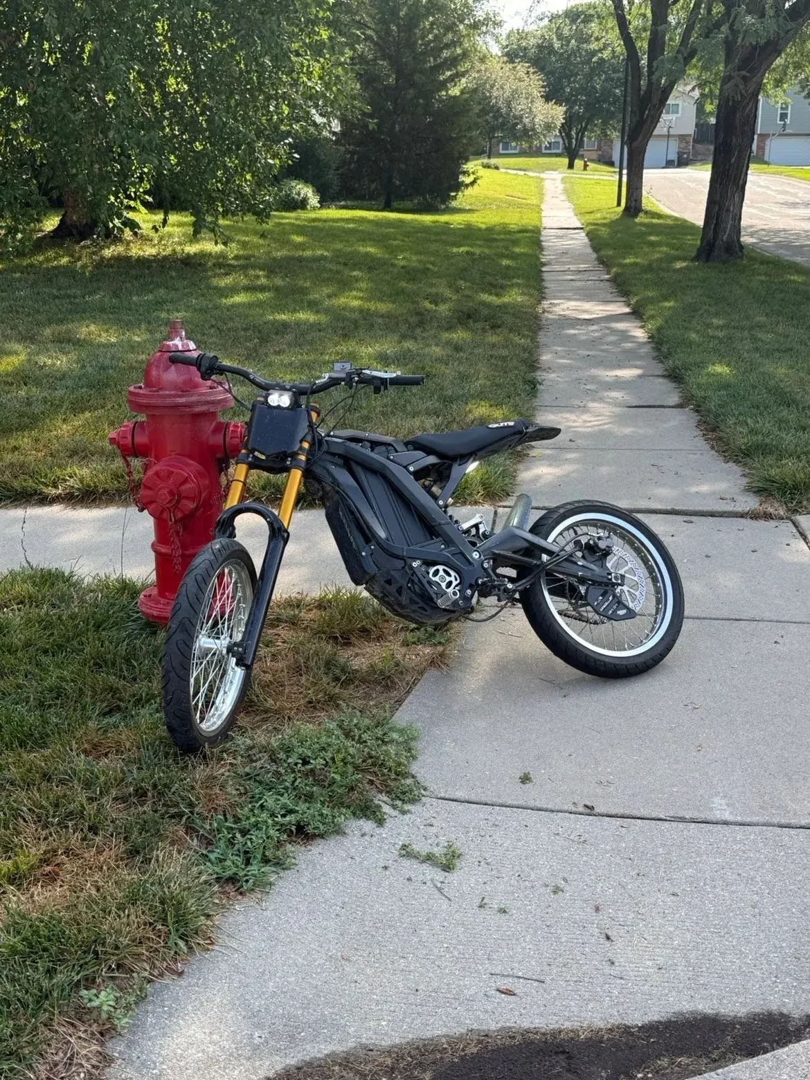 Black Sur-Ron Light Bee X with a gold 40s style front fork and supermoto wheels